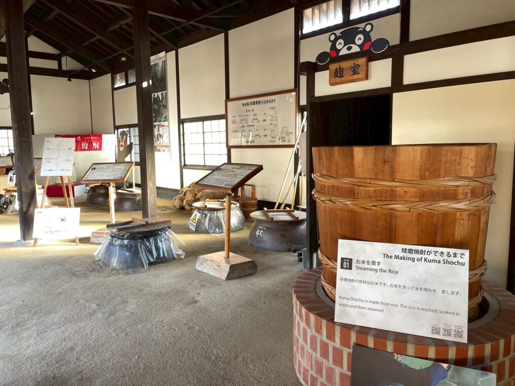 球磨焼酎の製造工程展示 お米を蒸すための木樽と解説パネル