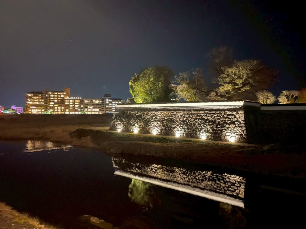 人吉城跡の石垣(跳ね出し石垣)がライトアップされ水面に映る様子