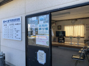 湯島行き定期船の江樋戸港待合室。壁には時刻表と運賃表が掲示されている。