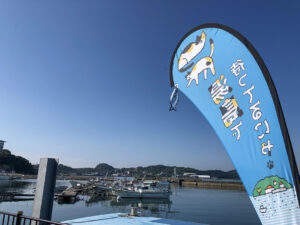 「待っとるにゃ 湯島」と書かれた猫のイラスト入り歓迎のぼり旗。湯島行き定期船乗り場の目印。