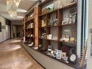 南阿蘇の作家作品が並ぶ「白水郷アートプレイス」の常設展示ショップ。緩やかにカーブした木の棚が特徴