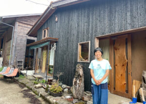 熊本県御船町にある國武林業の焼杉の事務所の前に立つ、創業者の國武信子さん。