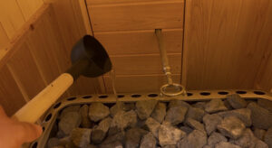 サウナストーブに積まれた熱いサウナストーンに、黒いひしゃくで水を注いでいるクローズアップ。ロウリュによる蒸気発生の瞬間。